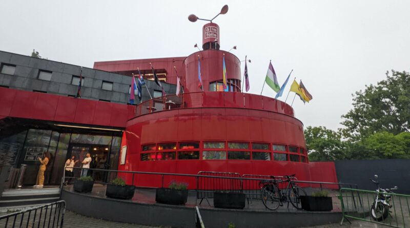 Le bar-restaurant à la folie est un bâtiment rouge et rond. Quand j'ai pris la photo, il était décoré de nombreux drapeaux représentant des identités LGBTQI+.