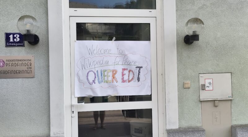 Une porte sur laquelle on voit un grand poster qui annonce, au feutre multicolore : Welcome to Wikipedia for Peace Queer Edit